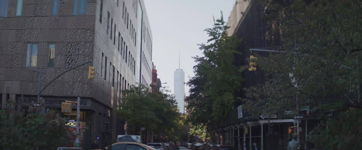 A pedestrian and cars on a city street