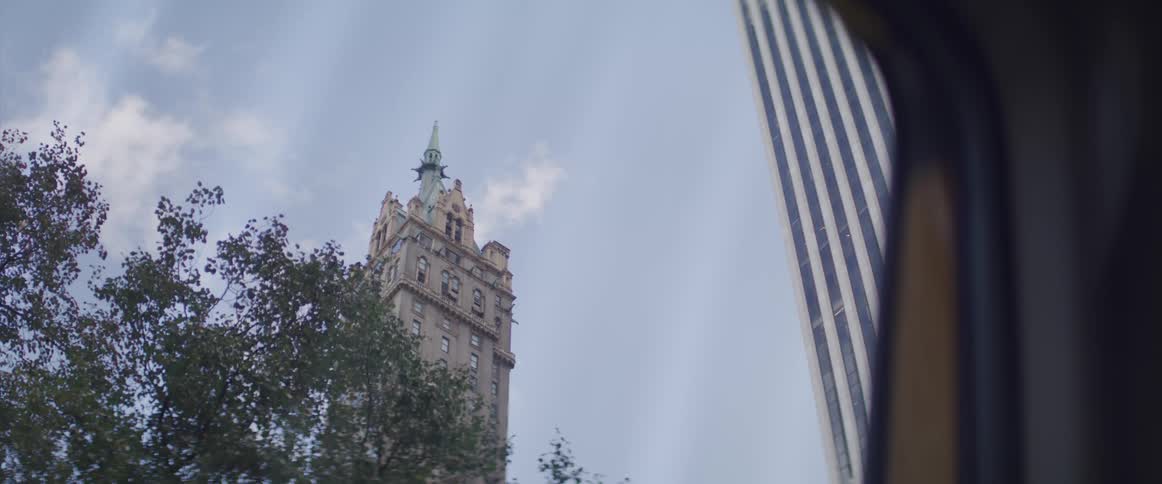 A historical building sits next to a tall modern skyscraper in a city