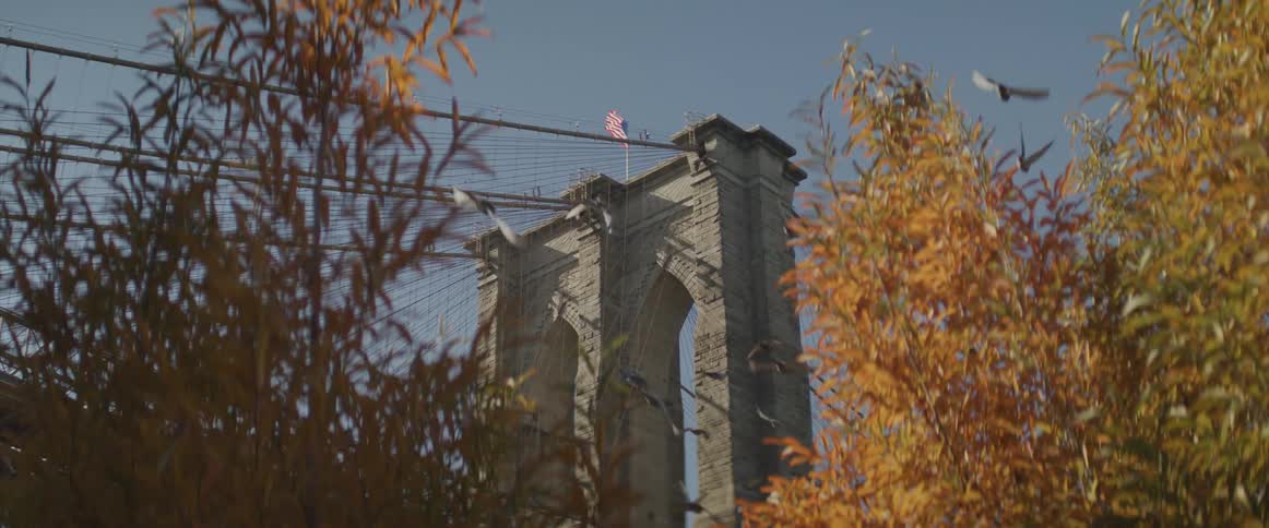View of brooklyn bridge tower and the american flag fluttering