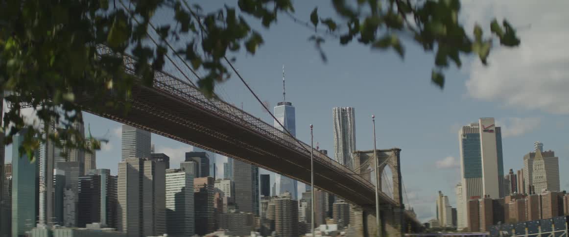 A suspension bridge crosses over into the downtown area of a city