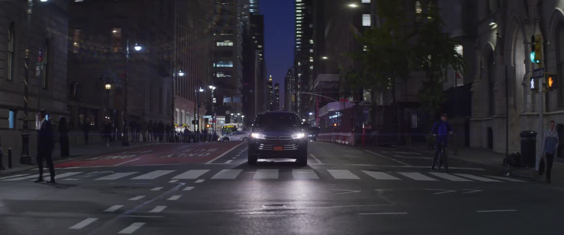 The car is stopped in the street as people cross