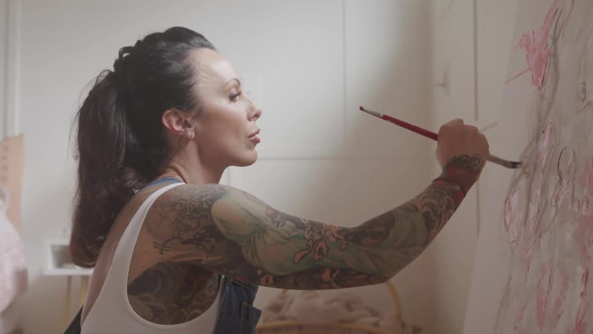 A woman paints on a canvas