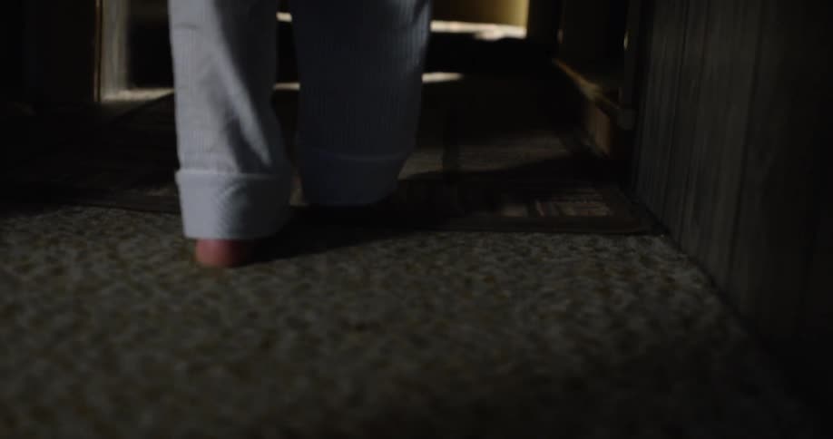 A person walks into a dark hallway