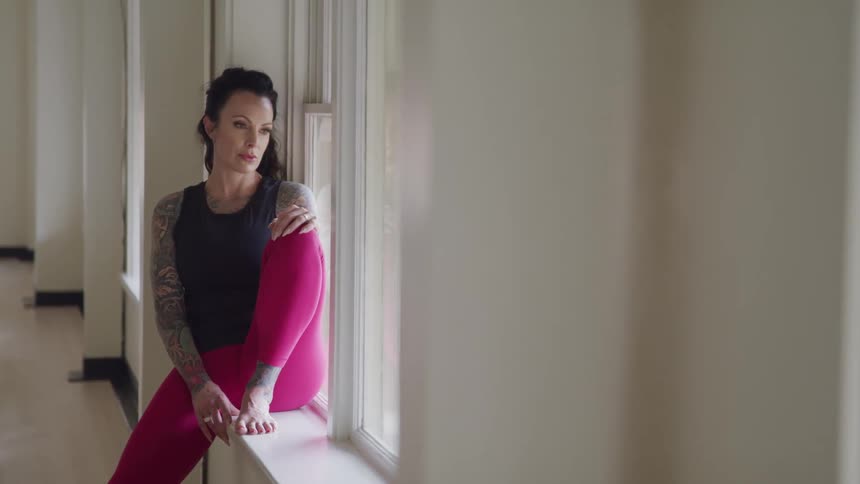 A woman sits on the windosill inside