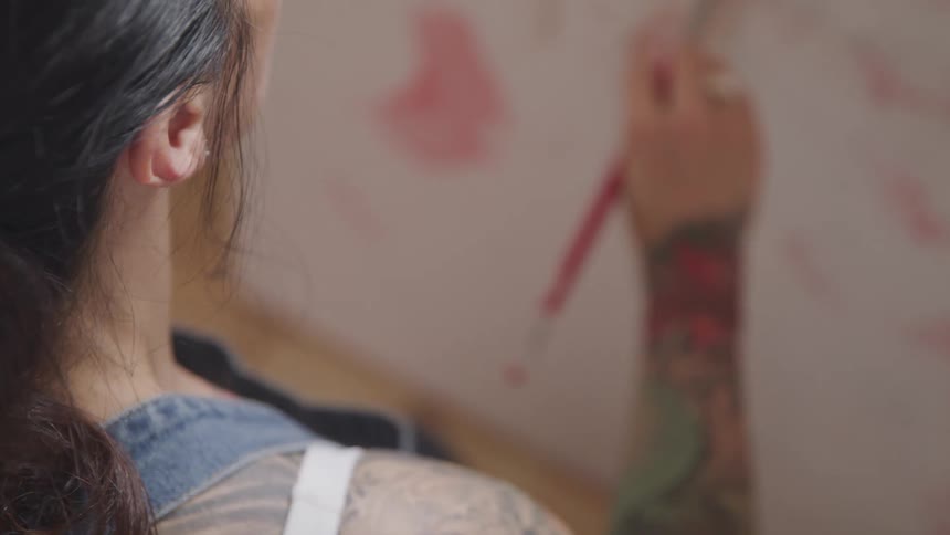 A woman paints on a canvas