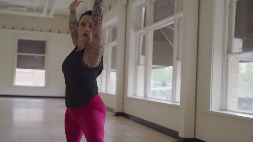 Female in a workout studio is concentrating while practicing pilates