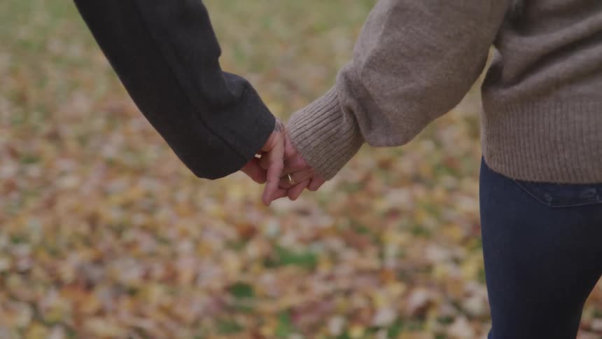 A man and woman walk hand and hand
