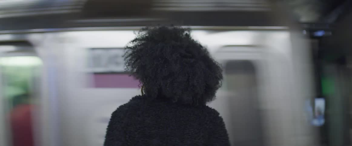 A woman sits as a train goes by