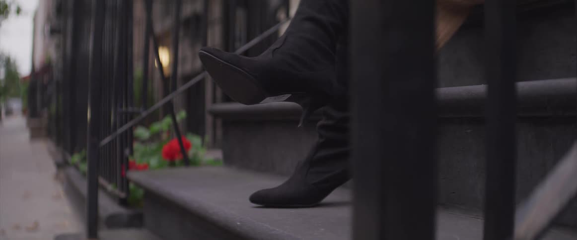 A woman sits on some steps outside