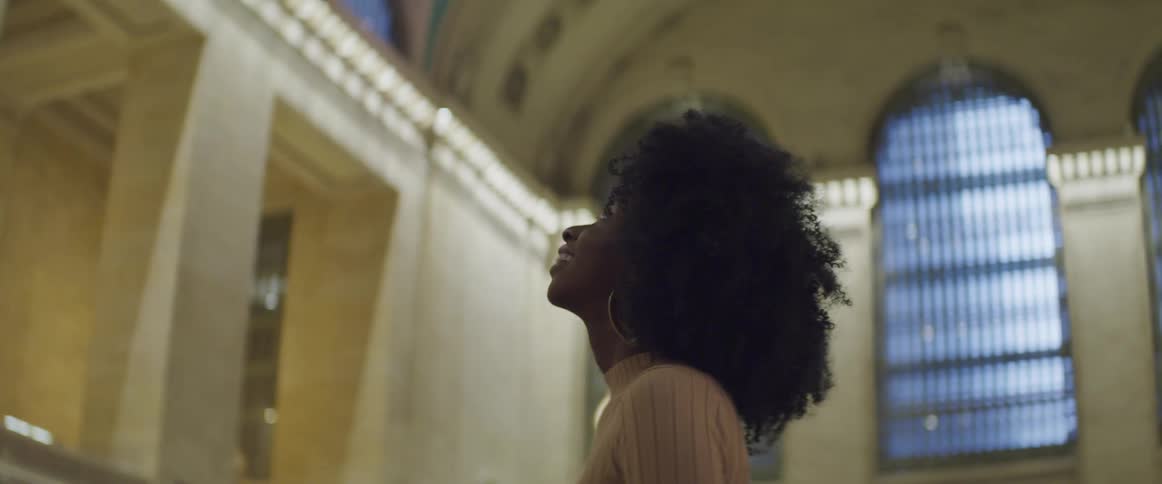 A woman stands in a train museum and looks around at the architecture