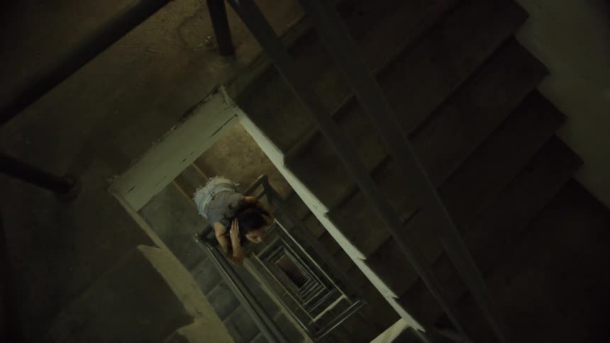 A woman looks up from the stairs