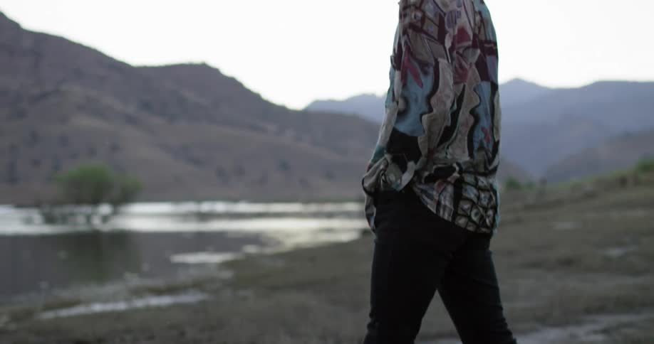 A man walks outside with his head down