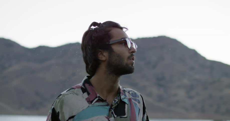 A man looks around in front of a mountain