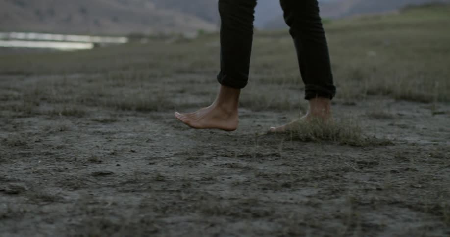 A man walks across a muddy field