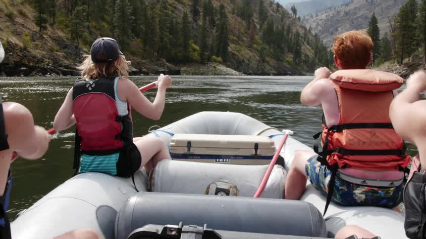 People paddling a boat down a river