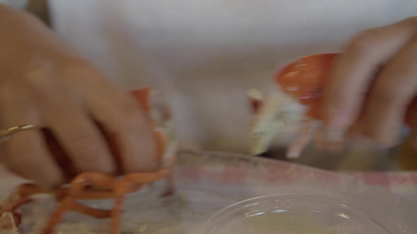 A woman prepares seafood in the kitchen