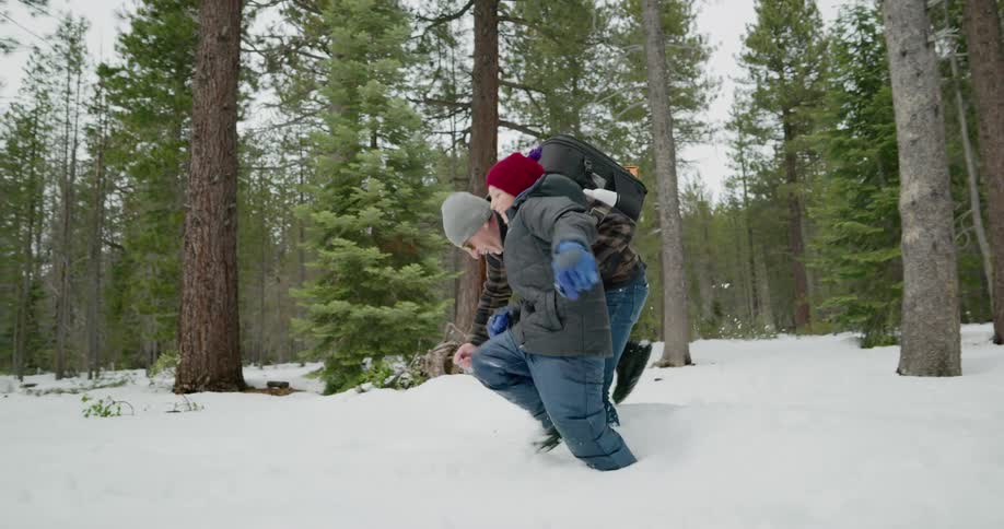 A father and sun hiking through deep snow in a forest