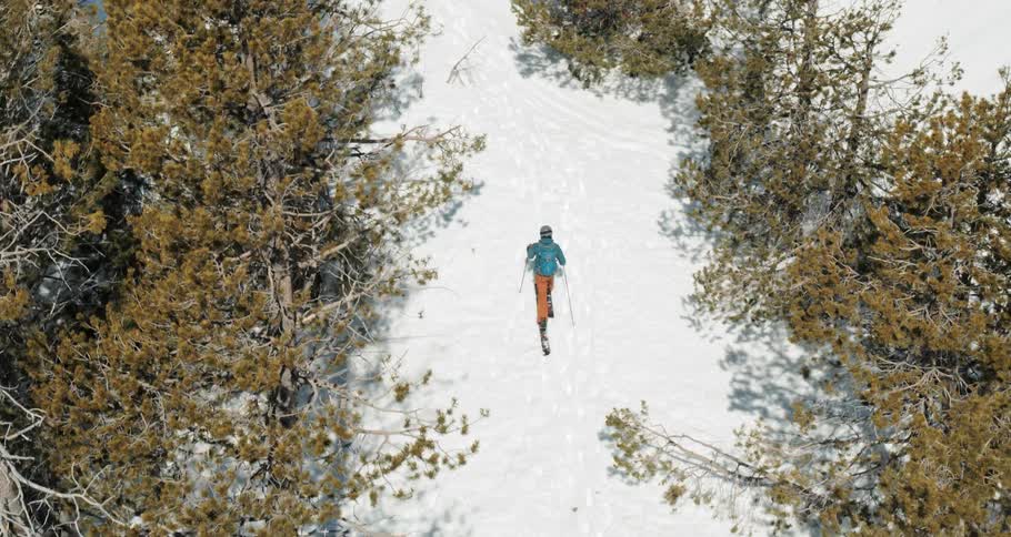 A person walks carefully through a snow terrain in full ski gear