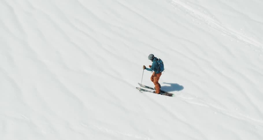 A skier climbs a snowy mountainside