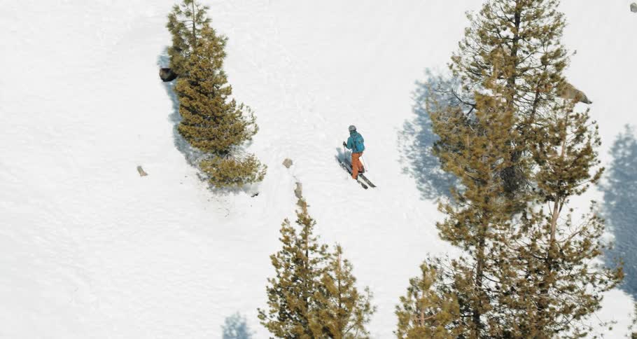A person walks in ski gear through a snow covered terrain