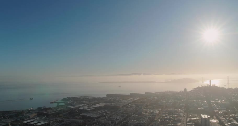 The sun shining down on a city on the coast