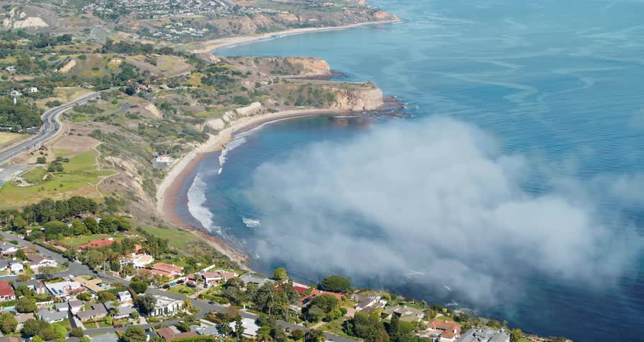 Thin clouds floating over a bay next to a small town