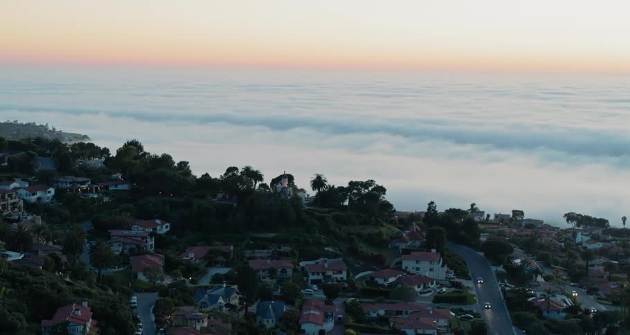 A couple of cars drive in the town below