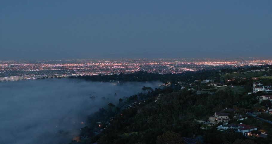 Fog obscuring a valley in the hills outside a city
