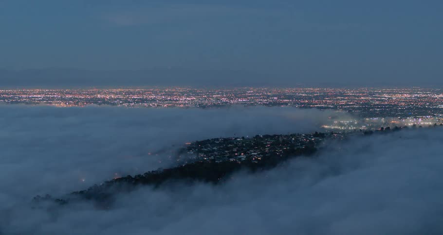 A city skyline with clouds above and the sky in the background