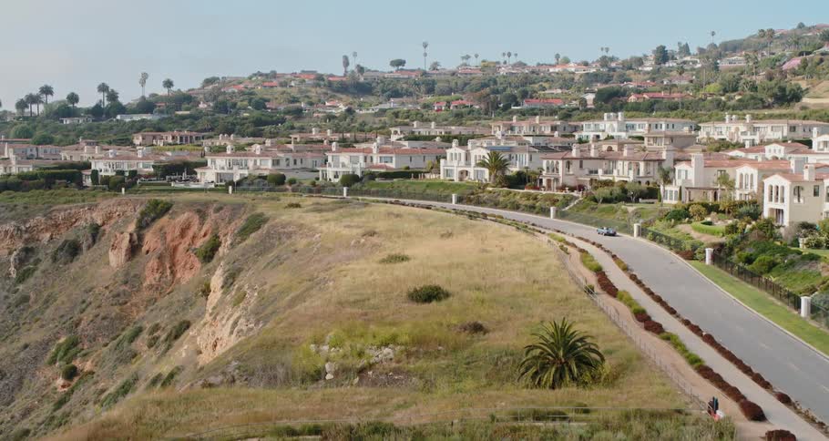 Car travels on a winding road on the top of a hill
