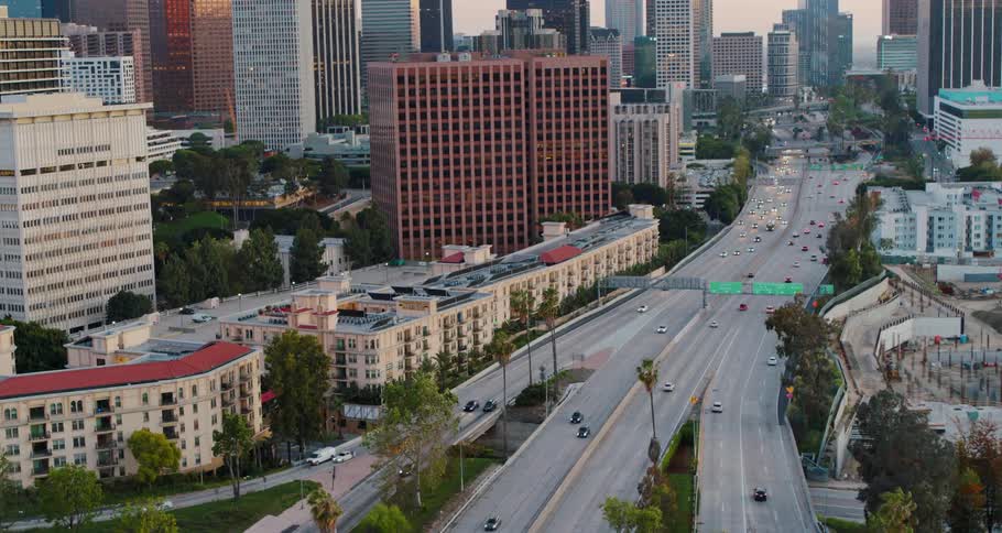 Aerial view of traffic on highway through city at sunset