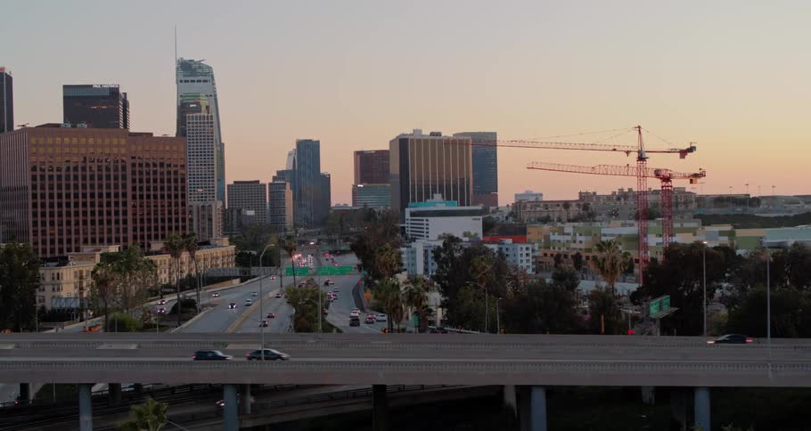 Traffic on highway through city downtown at sunset