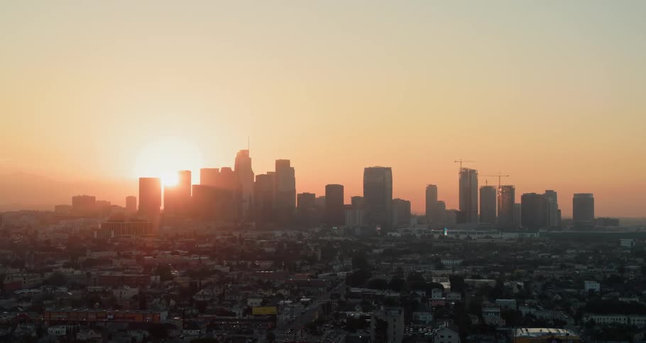 The sun rises behind a city skyline