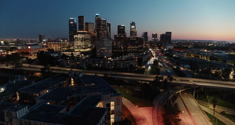 The vehicles travel towards the city at sunset