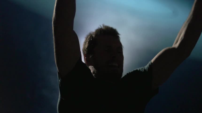Man does pull ups in a dark room