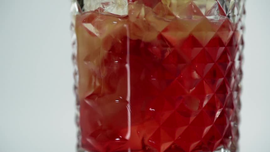 A glass fills with an alcoholic liquid