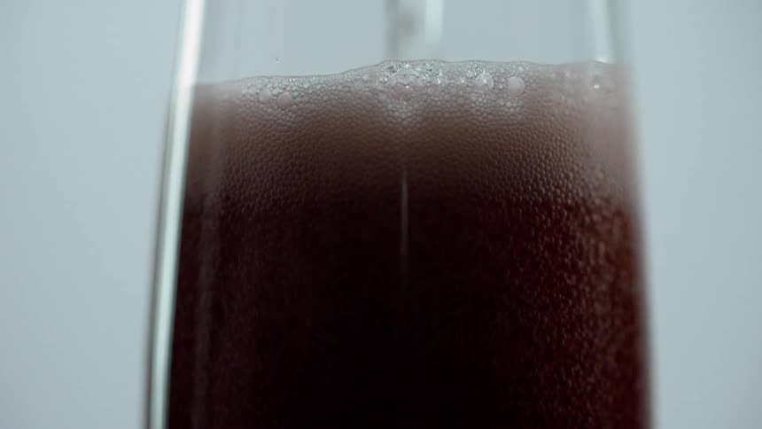 The glass is being filled with alcohol