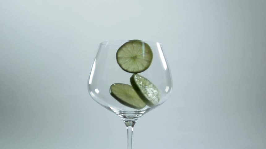 The lime slices drop into the glass
