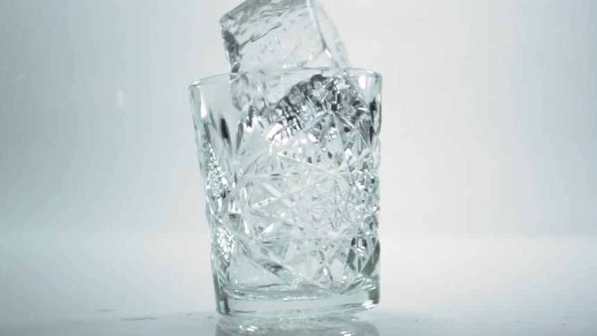 An ice cube gets put into a glass