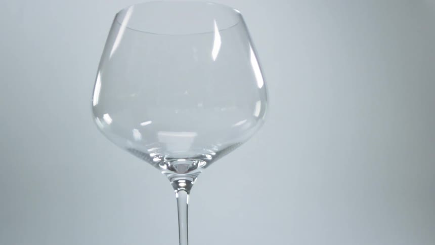 An empty wine glass tips and spins slightly