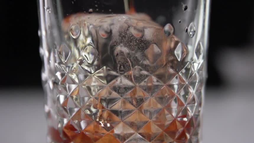 A cocktail is poured into the glass