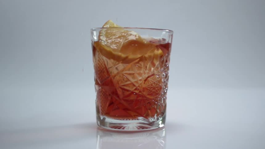 The lemon drops into the drink