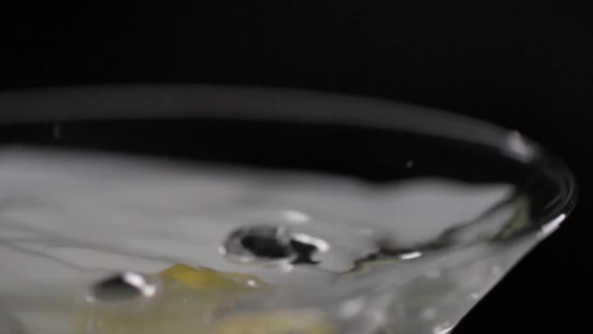 Lemon peel falls into a glass of water