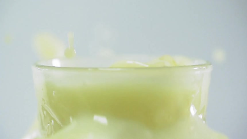 Ice drops and splashes a beverage out of a glass