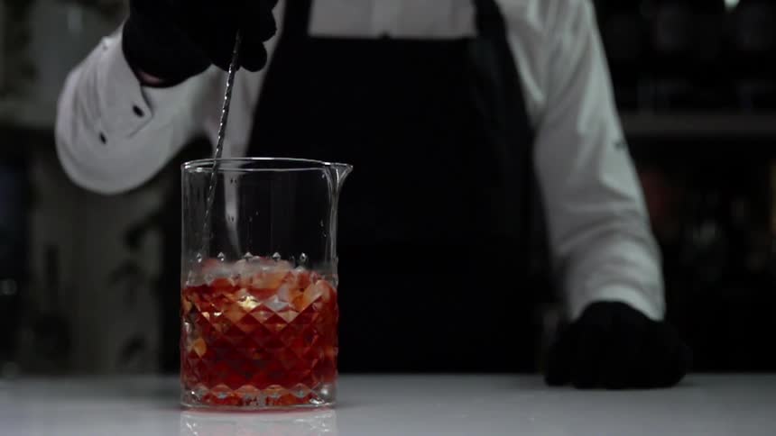 Bartender stirs the cocktail in a bar