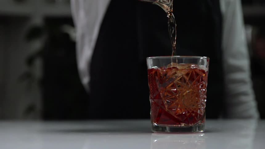 The person pours the drink