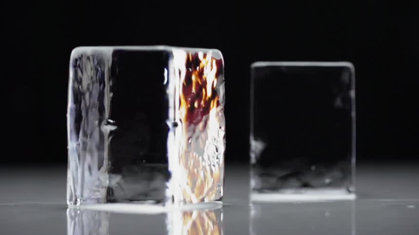 Two ice cubes rotating reflecting light