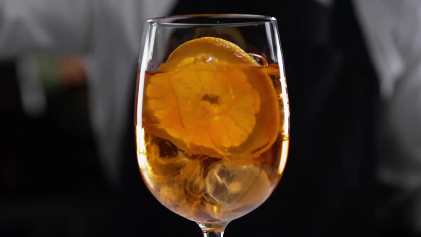 A person puts a slice of lemon in a drink