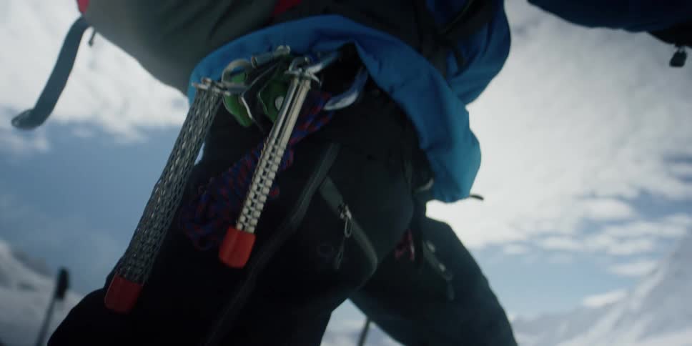 A skier treks out of a base camp in the snowy mountains