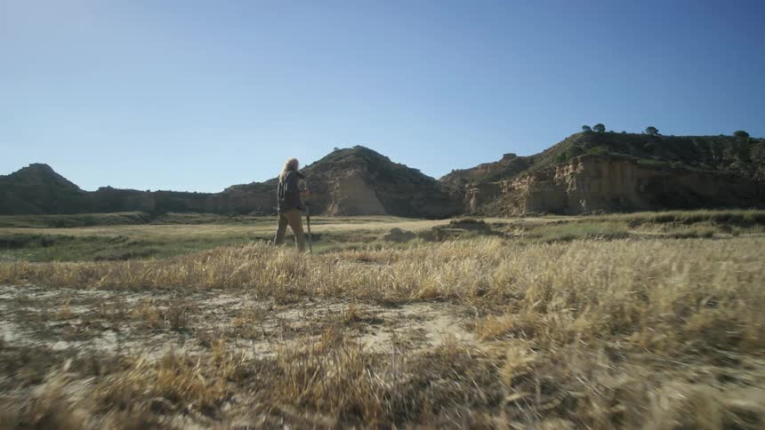Man hikes across plains on a sunny day
